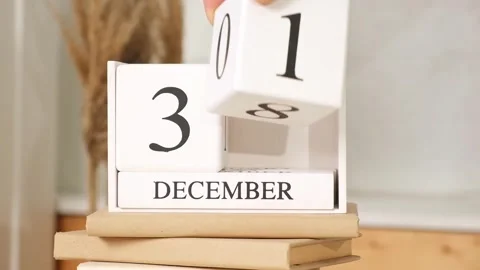 Man puts the date December 31 on the calendar. White block calendar present date Stock Footage 242298678