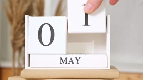 The man puts the date May 1 on the calendar. May 1st. may 1 wooden calendar on Stock Footage 242444218