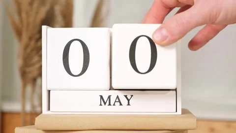 The man puts the date May 1 on the calendar. May 1st. may 1 wooden calendar on Stock Footage 245657207