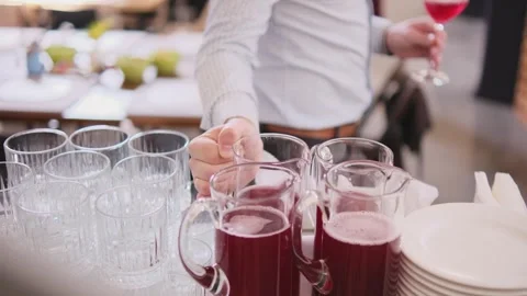 A man puts a decanter of juice on the table Stock Footage 310694743