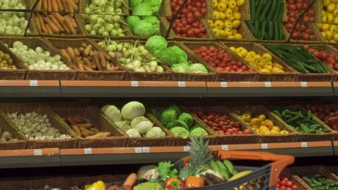 Man puts different vegetables into the shopping cart Stock Footage 76680217