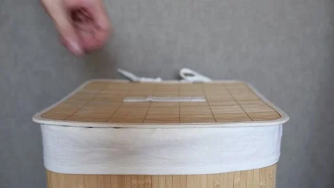 Man puts dirty laundry in a laundry basket made of bamboo. Housework. Home Stock Footage 157326533