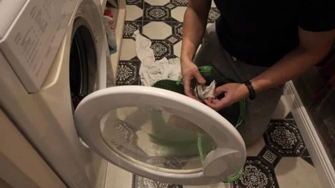A man puts dirty laundry in the washing machine. Vídeo Stock 145157679