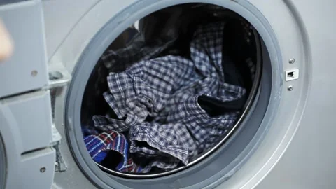 Man Puts Dirty Things in The Washing Machine. Concept of Household Chores Stock Footage 153536473