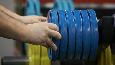 Man puts the disc on the barbell close up. Stock Footage 125059140