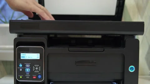 A man puts a document on the scanner to scan and tries to start Stock Footage 146318543