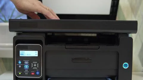 A man puts a document on the scanner to scan and tries to start Foto stock