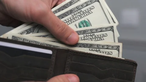 Man puts dollars in his wallet, closeup hands 스톡 동영상 130026221