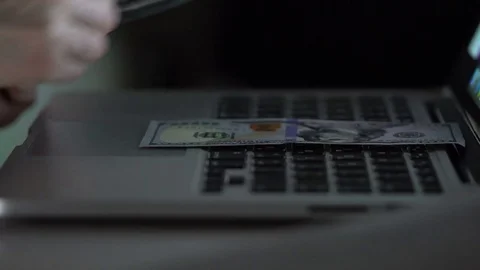 Man puts dollars on a laptop. Stock Footage 73457402