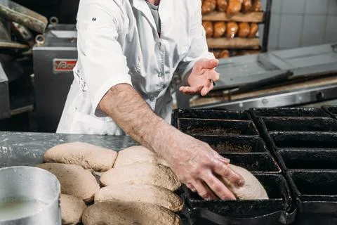 A man puts dough in a bread pan. Bread making process Stock Photos