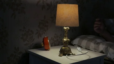 Man puts down alarm clock and turns the light off Video stock 72641299