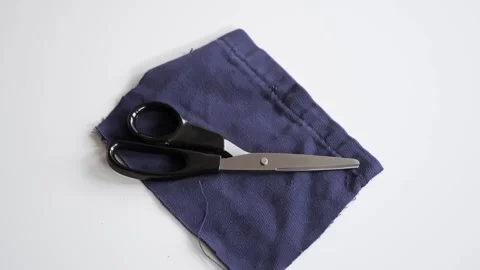 A man puts down the scissors on denim. Recycling things. Making a new elements Stock Footage 323705812