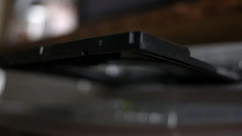 Man puts a DVD disc into a DVD player slot Stock Footage 90104115