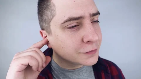 The man puts on earplugs. Close-up of an orange noise barrier. Deep sleep. The E Stock Footage 187968902