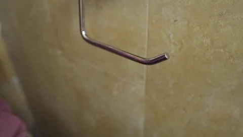Man puts an empty roll of toilet paper back in holder Stock Footage 82312756