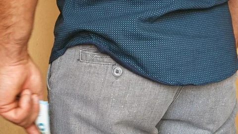 A man puts euro banknotes in the back pocket of his trousers. A man hides money Video stock 113857485