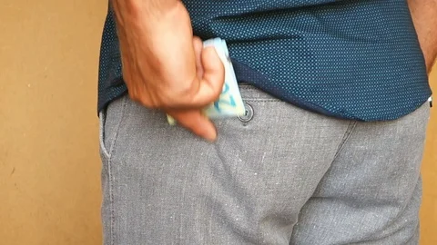 A man puts euro banknotes in the back pocket of his trousers. A man hides money Video stock 114068759