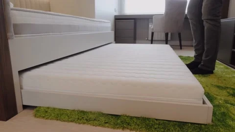 A man puts an extra bed in a child's bed. Stock Footage 130351146