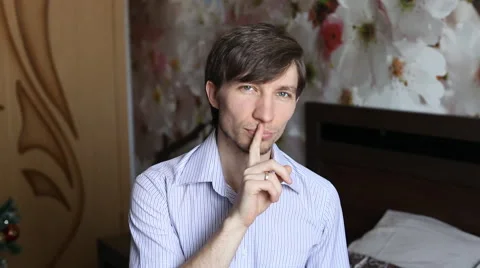 Man puts a finger to his lips, gets flowers - tulips and then winks Stock Footage 60053942