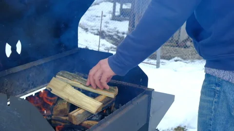 A man puts firewood to light a fire for barbecue in nature Stock Footage 170462792