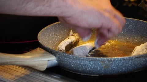 Man puts fish in a pan Stock Footage 125009596