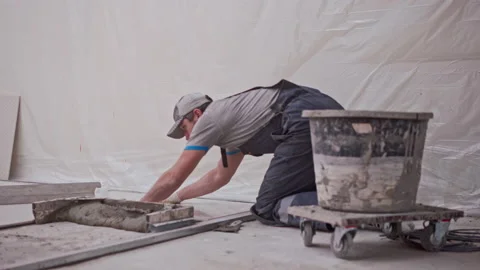 Man puts floor tiles Stock Footage 145973856