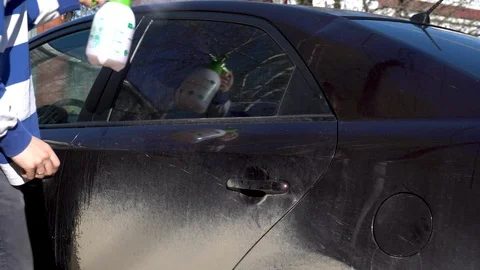 A man puts foam on a car to remove dirt. Special detergent for car wash. Washes Stock Footage 129750027