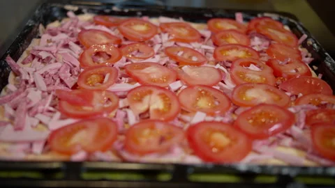A man puts fresh chopped tomatoes on a home-made pizza, close-up Stock Footage 131971052