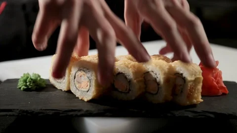 Man puts fried sushi rolls on table. Close-up. 스톡 동영상 87233288