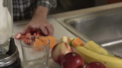 A man puts fruit into a blender, in close-up. Stock Footage 44116989