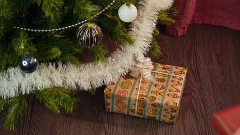 А-man-puts-gifts-under-the-tree Stock Footage 144314721