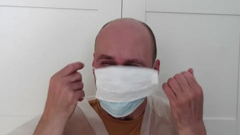 A man puts on glasses a double protective hygienic disposable medical mask Stock Footage 152343340