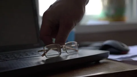 Man puts glassess on notebook surface and moves mouse Stock Footage 121832906