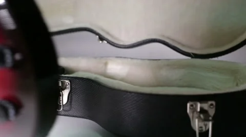 A man puts a guitar into the case. Stock Footage 57747003