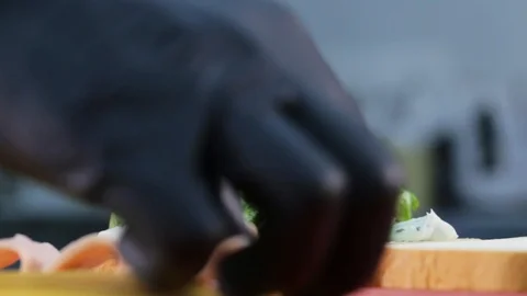 Man puts ham on bread with lettuce while cooking sandwich. Stock Footage 108332258