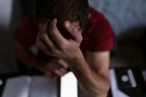 Man puts hand on head trying solve the problem, calculation Stock Photos
