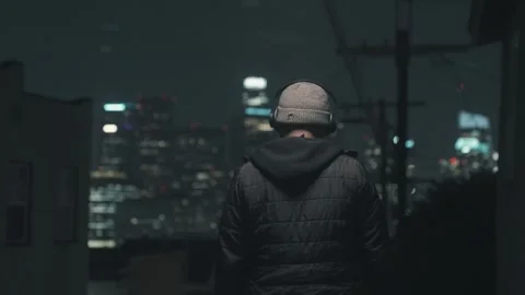 A man puts on headphones while walking away from camera Video stock 301392710