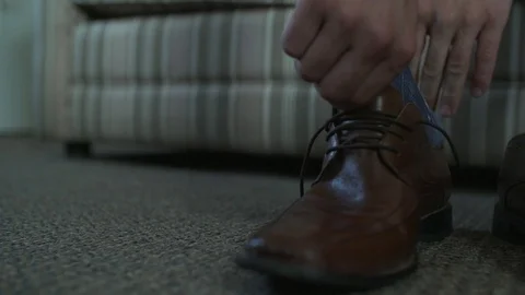 A man puts his foot into a brown dress shoe. Vidéo 101325205