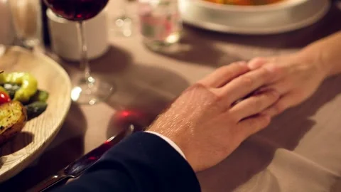 Man Puts His Hand on a Woman's Hand on a Chic Restaurant Table Stock Footage 262563045