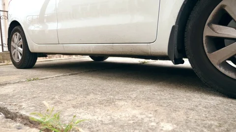 A man puts a homemade explosive device under the car. Preparation of terrorist Stock Footage