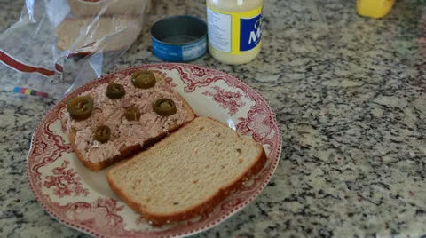 A man puts hot sauce on a tuna fish sandwich Stock Footage 32906875