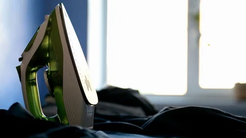 Man puts the iron on the board and is going to iron Stock Footage 109790761