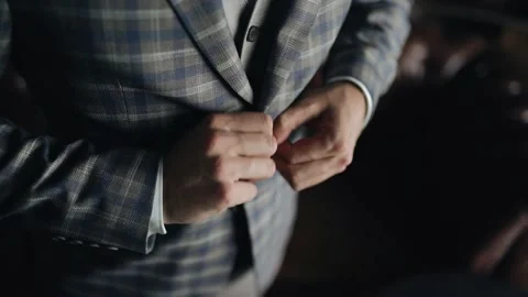 A man puts on a jacket. He's going to a meeting. Close-up of clothing details Видео 163894724