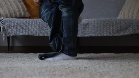 A man puts on jeans. only legs are visible. Stock-Footage 274949062