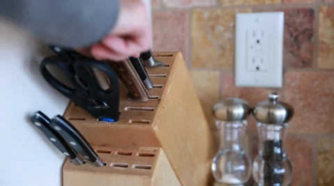 Man puts knife in knife block Stock Footage 32906698