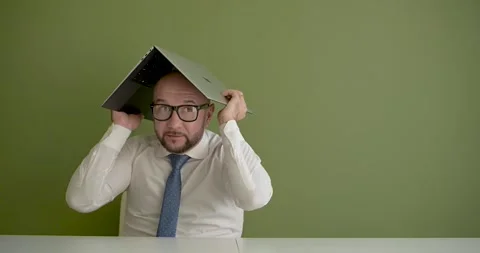 A man puts the laptop on his head and hides Stock Footage 267088066