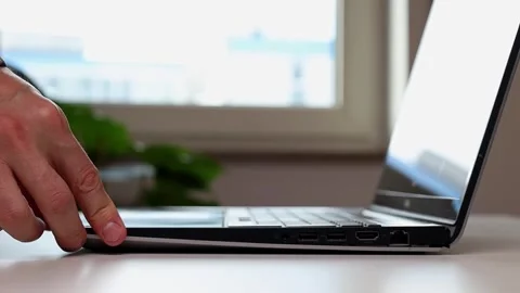 A man puts a laptop on the table, opens it, starts typing Video stock 244599152