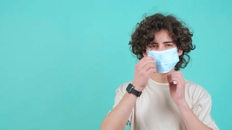 Man puts a mask on his face from coronavirus and doing thumb up gesture. 스톡 동영상 151914049