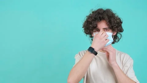 Man puts a mask on his face from coronavirus and doing thumb down gesture. Stock Footage 152844686