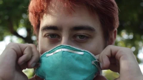 Man Puts on Mask Outdoors, Close Up Stock Footage 134739172